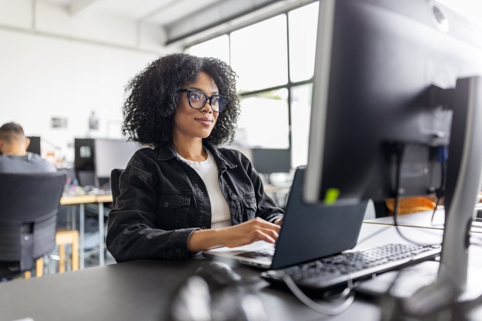African businesswoman working on a computer at her office desk.