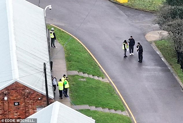 Migrants are seen standing outside the barracks this morning after their arrival at the camp