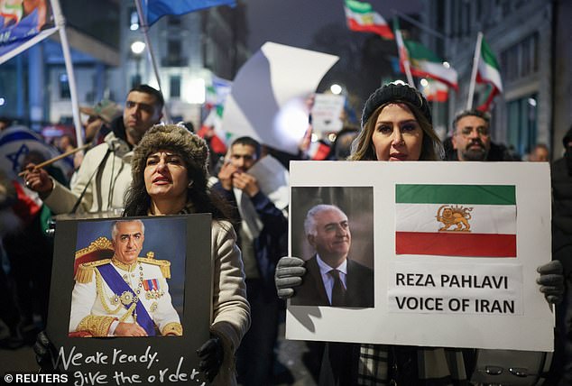 Protesters in London hold placards carrying the image of exiled crown prince Reza Pahlavi