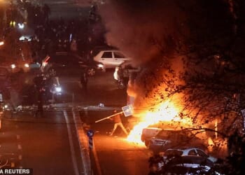 Iranian demonstrators gather in a street during a protest over the collapse of the currency's value, in Tehran, Iran