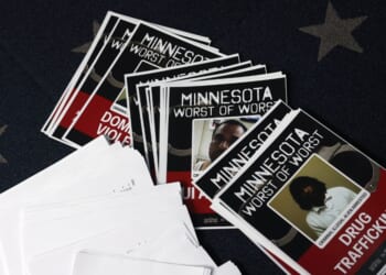 Documents with mugshots labeled "Minnesota Worst of the Worst" are scattered as President Donald Trump speaks during a news briefing in the James S. Brady Press Briefing Room of the White House on Jan. 20, 2026, in Washington, D.C.