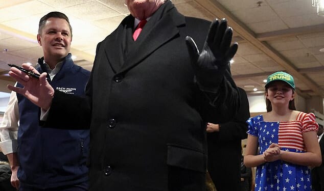 Representative Zach Nunn (R-IA) and his daughter Olympia look at U.S. President Donald Trump as he speaks, in Machine Shed restaurant in Urbandale, Iowa, on Tuesday