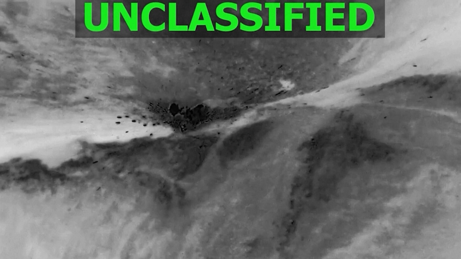 An abstract grayscale image with the word "UNCLASSIFIED" in green at the top.
