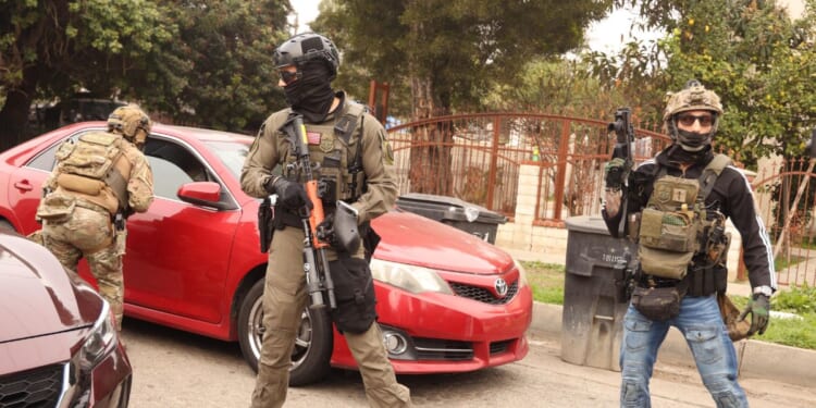 Border Patrol agents and other law enforcement ask a car to make room for a police vehicle to pass while investigating a shooting involving a federal agent on Wednesday morning in Willowbrook on Jan. 21, 2026.