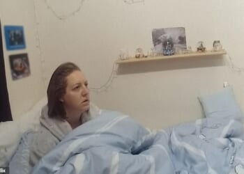 Lucy Letby in bed looking bewildered as a police officer explains her rights and arrests her