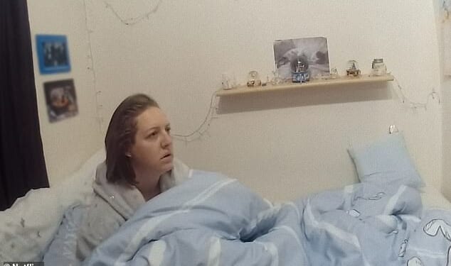Lucy Letby in bed looking bewildered as a police officer explains her rights and arrests her