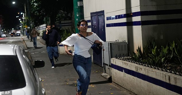 Pedestrians run after explosions and low-flying aircraft were heard in Caracas, Venezuela, Saturday, Jan. 3, 2026. (AP Photo/Matias Delacroix)