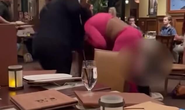 Video from the Cork & Bull Chophouse in Chesapeake shows a women in a black ensemble grabbing a woman wearing hot pink by her hair and punching her repeatedly on November 6