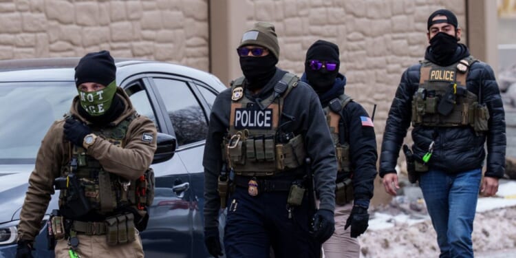 Immigration and Customs Enforcement agents walk near vehicles in Richfield, Minnesota, on Jan. 15, 2026.