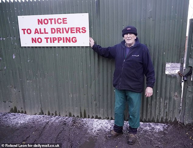 Carl Powell next to his 'no tipping' warning sign at an entrance to Stone Arrow Farm