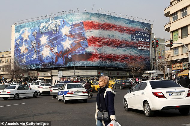 A giant banner depicting a US aircraft carrier and the American flag displayed at Enqelab (Revolution) Square in Tehran on January 25
