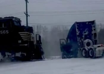 Heart-stopping moment train smashes into a truck stuck on the rail line after a 'bomb cyclone' snowstorm