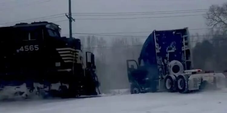 Heart-stopping moment train smashes into a truck stuck on the rail line after a 'bomb cyclone' snowstorm