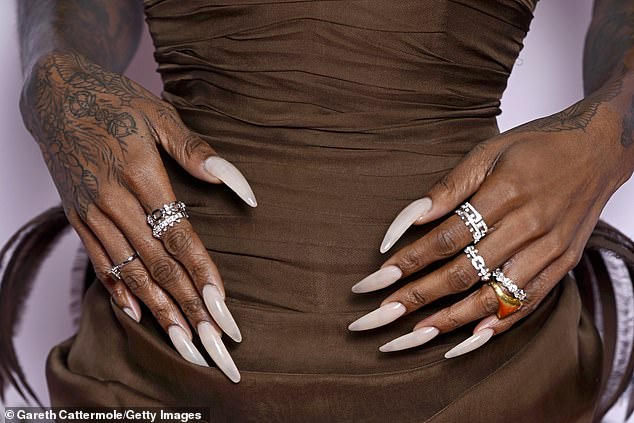She showed off her signature long nails which were pained a neutral pale colour
