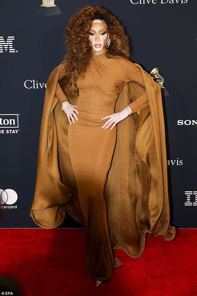 Winnie Harlow showcased her model figure in a muted orange gown with a dramatic, flowing cape