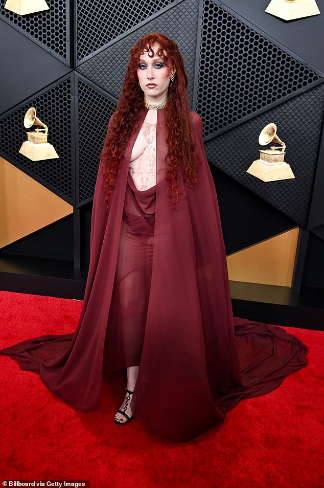 She originally covered up with a shawl draped over her chest area, but as she posed for photographers she removed the piece of fabric, leaving her breasts on full display