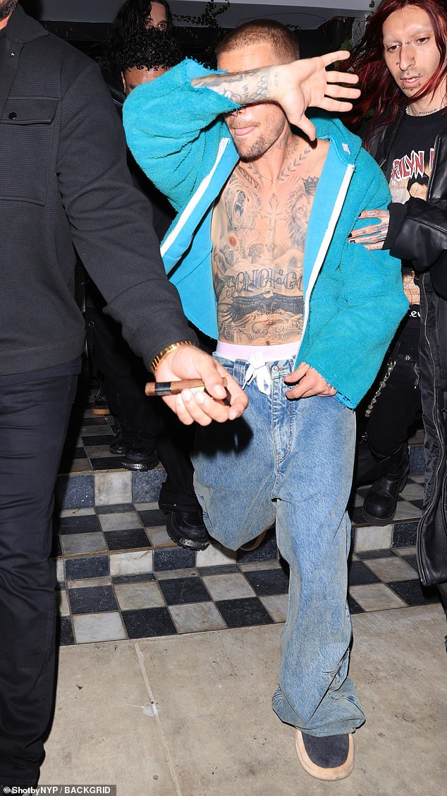 He was surrounded by aides and friends as he left the paparazzi packed bash