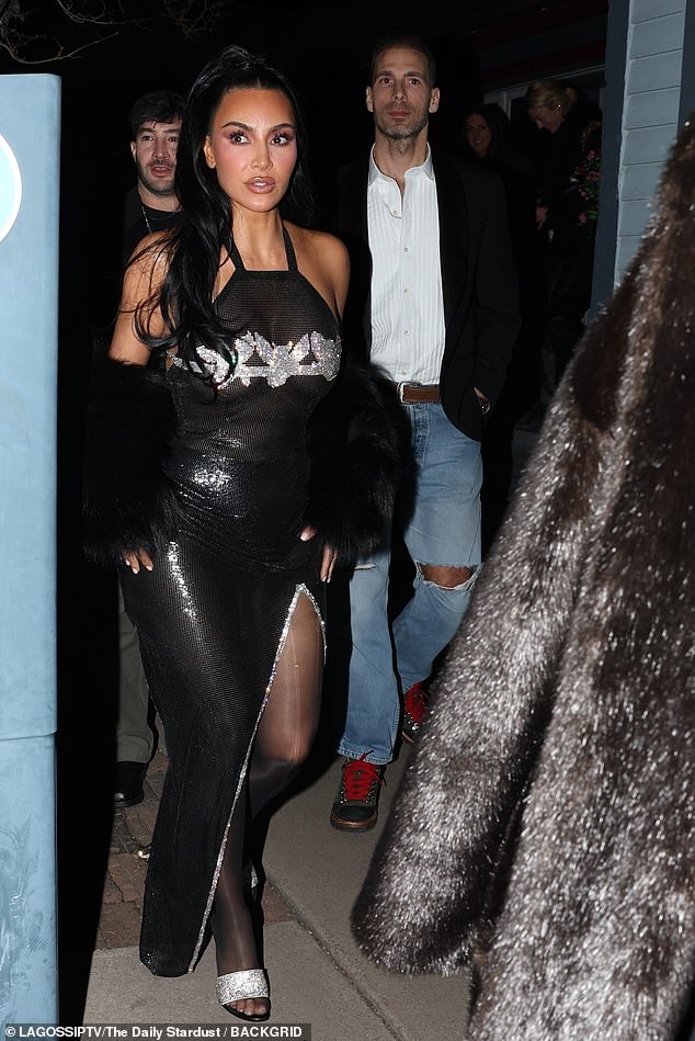 On the night, Kim flaunted her hourglass curves in a form-fitting sparkly black dress with glitzy detailing that covered her bust and a black fur stole