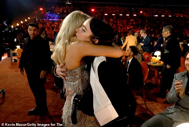 (L-R) Sabrina Carpenter hugged Billie Eilish as Nat Wolff looked on
