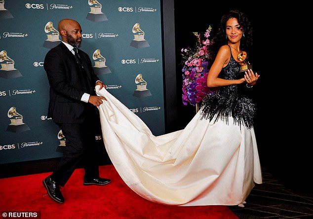 Olivia Dean has her train lifted as she carried the Best New Artist award