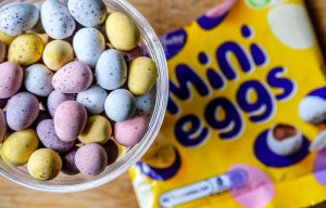 A clear bowl of colorful Mini Eggs next to a yellow bag of Mini Eggs.
