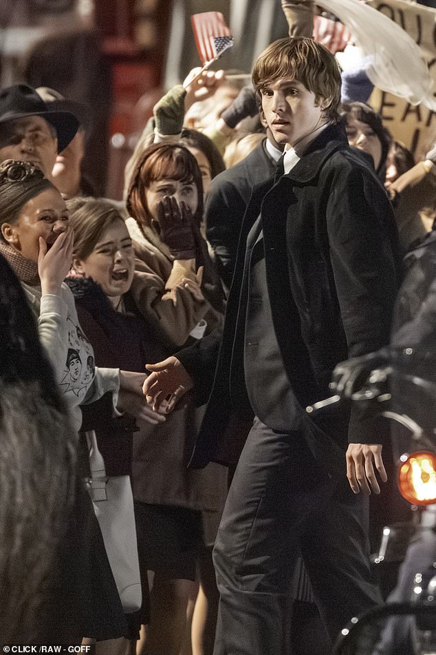 A perplexed looking John Lennon, played by Dickinson, quietly observes the madness