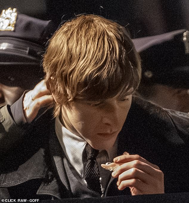 Dickinson appears to hold a dental plate during his latest appearance on set, suggesting the use of prosthetics in his portrayal of John Lennon