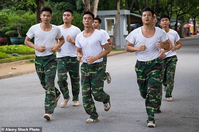 Vietnamese soldiers run in training outside their base