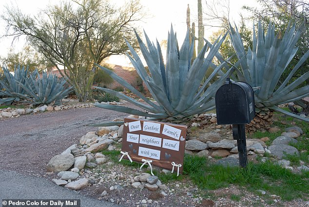 Outside Nancy's Arizona home, where neighbors left a sign saying they 'stand with' the 84-year-old and her family
