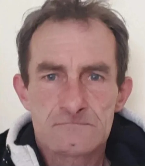 Headshot of a man with blue eyes and brown hair.