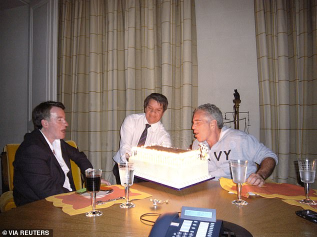 Mandelson sits with Epstein as he blows out the candles on a cake in a photo released in by the US Department of Justice