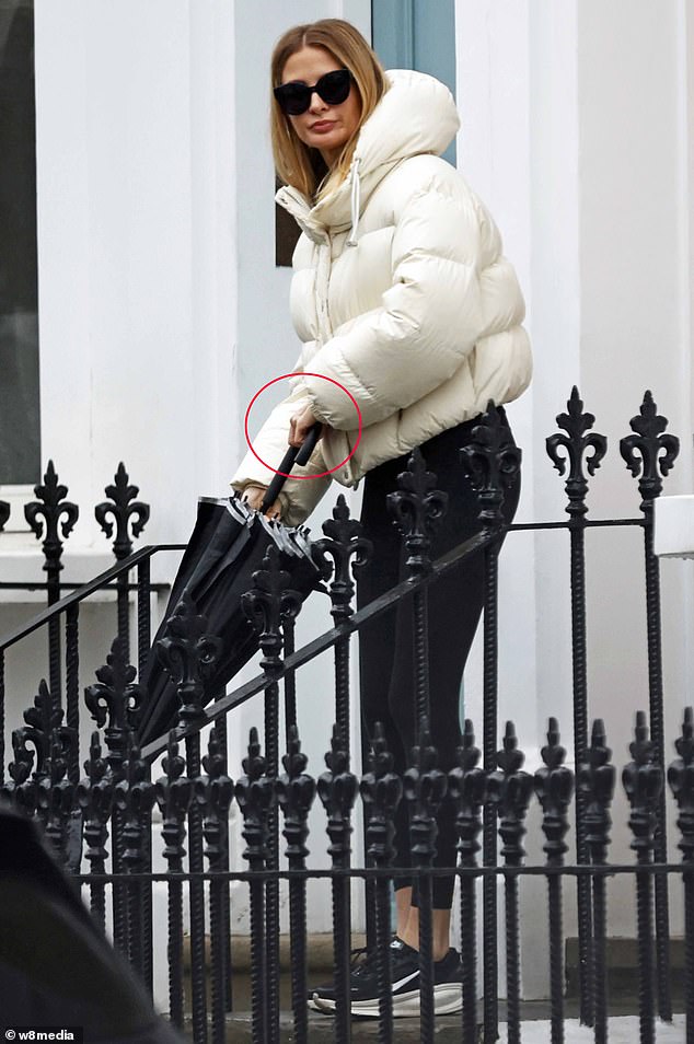 Venturing out in London, Millie, 36, looked downcast and concealed her wedding ring finger, after taking it off in previous days