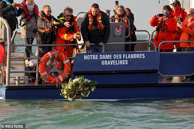 Crew members of a Societe Nationale de Sauvetage en Mer (SNSM) lifeboat throw flowers into the sea on November 24, 2022, to pay tribute to the men, women and children who died one year earlier