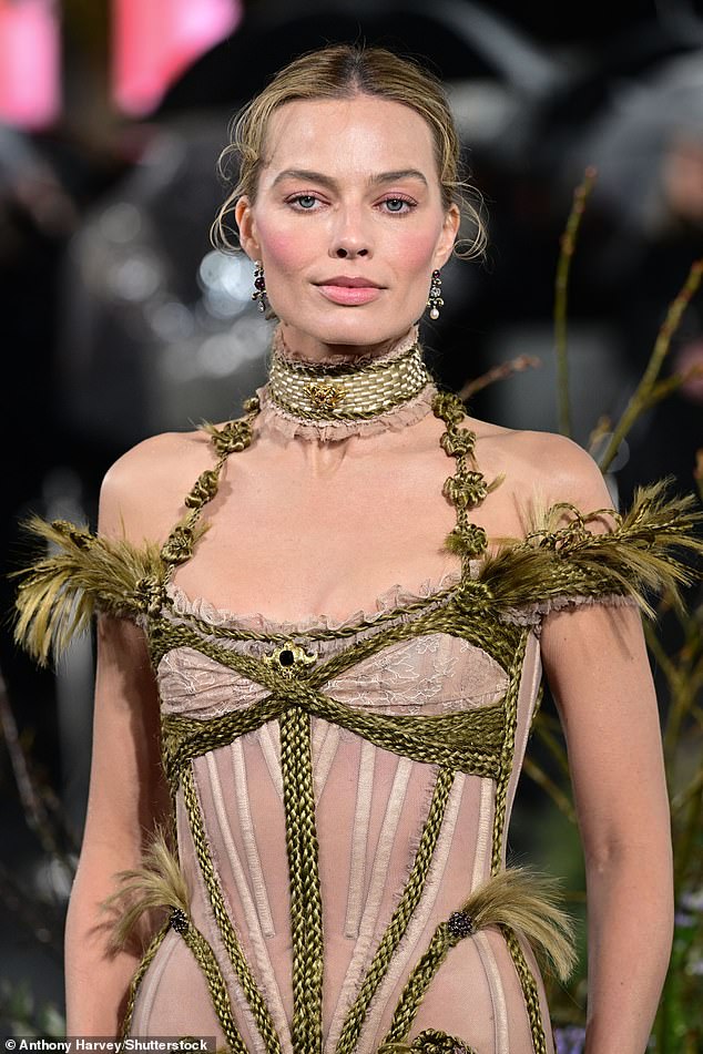 The Barbie star's dress was adorned with green knotted detailing and feathers, nodding to the jaw-dropping looks that will feature in the film