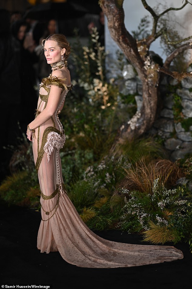 While the train in Margot's dress suffered at the hands of the British rain, her look certainly stole the show with its nods to her period character in the film