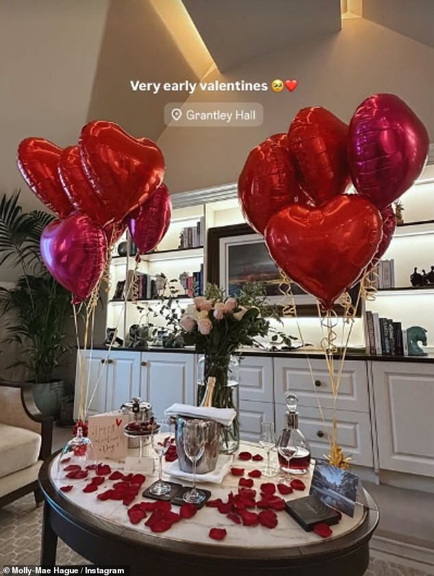 Sharing a snap to Instagram of her bed covered in rose petals and an array of red heart balloons, Tommy treated her to flowers, bubbly and gifts