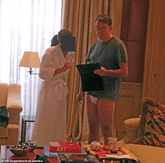 In this photo, Peter Mandelson stands in white underwear talking to a woman in a bathing robe