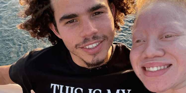 Elajah Williams smiling with loved on by the water.