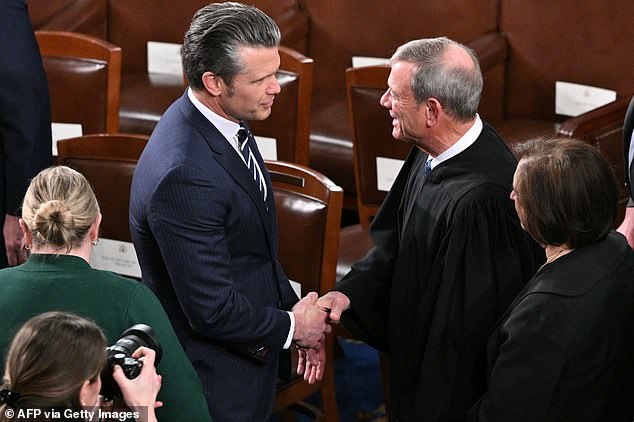 Department of War Secretary Pete Hegseth shakes hands with Chief Justice Roberts as they arrive for the State of the Union