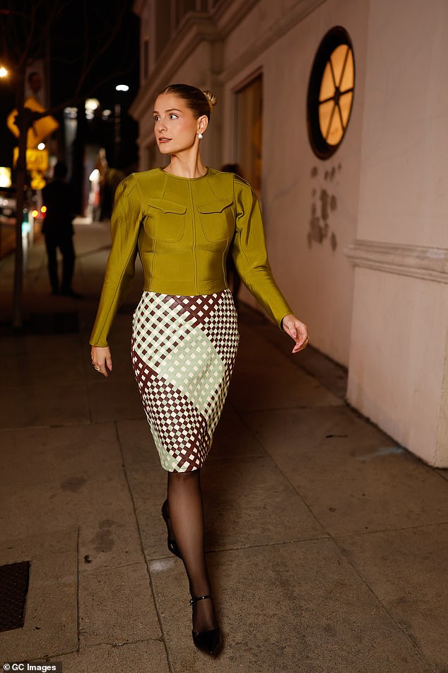 The Lips Are Movin' hitmaker, 32, who recently welcomed her third child via surrogate, teamed the green top with a brown checked figure hugging midi skirt and black heels