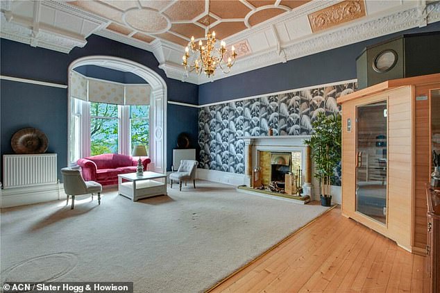 A spacious drawing room with a marble fireplace on the ground floor of the Scottish castle