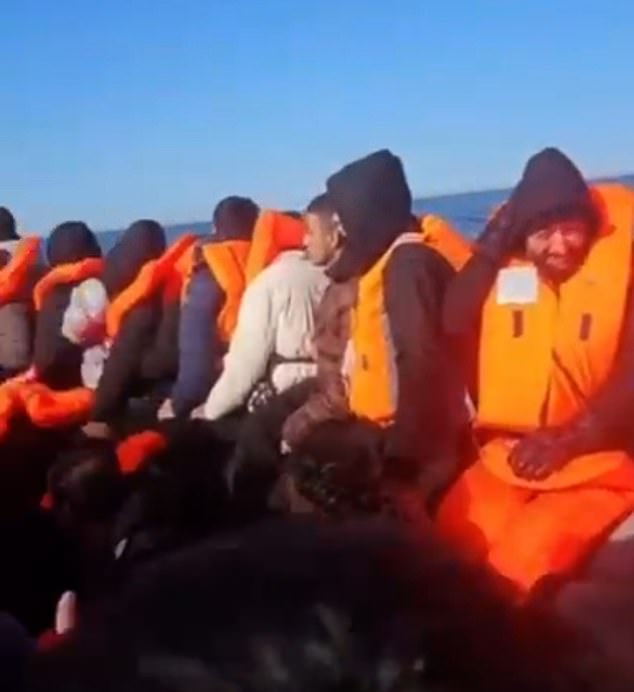 Migrants can be seen travelling by small boat across the English channel