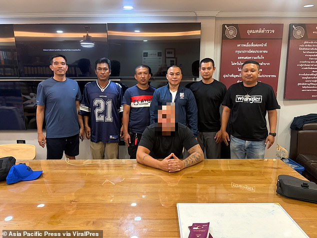 The attacker was pictured in front of six cops after he allegedly confessed to the crime and was charged with 'assault resulting in death'