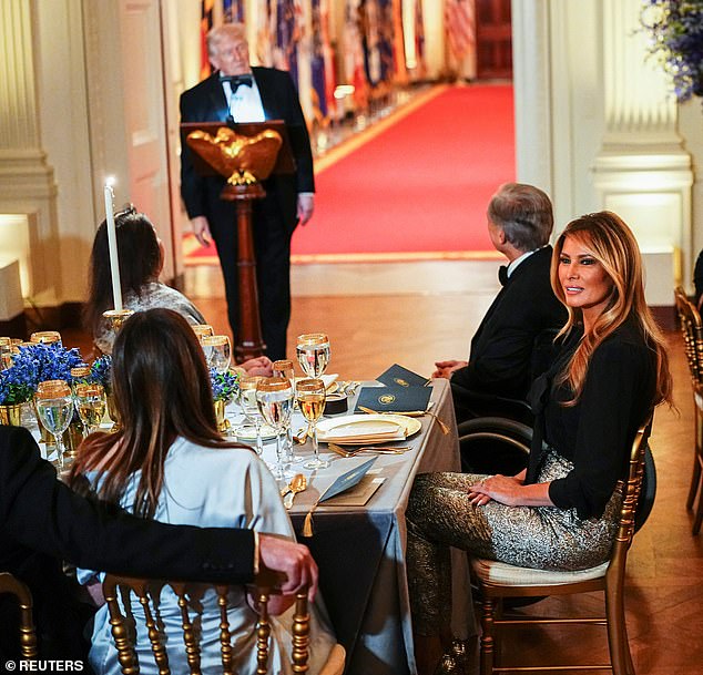 The First Lady wore $2,395 metallic silver trousers by Dolce & Gabbana, one of her favorite designers, for the occasion, pairing the cigarette-style brocade pants with a long-sleeve, black tie-neck blouse from the same brand