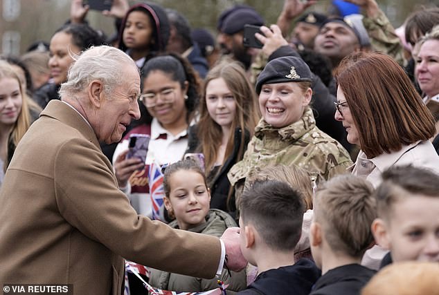 Hundreds of personnel and their families greeted the King, who arrived wearing a suit and regimental tie
