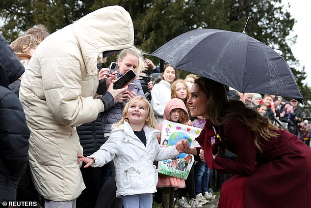 A toddler flashes a sweet smile as she poses for a photo alongside the Princess of Wales