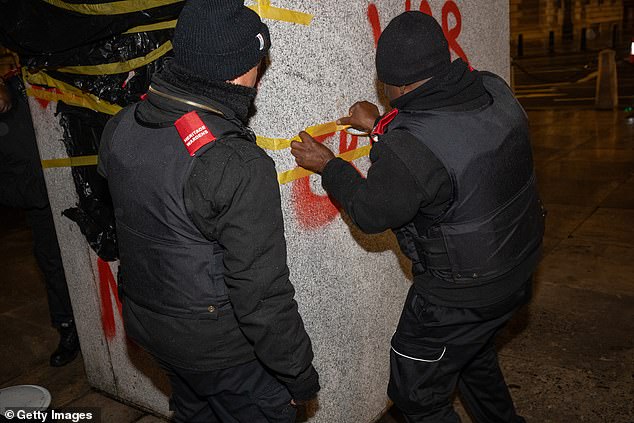 Westminster heritage wardens begin covering the graffiti with tape and plastic bin bags