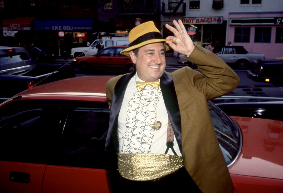 Neil Sedaka posing in a yellow fedora, gold bow tie, and sparkling cummerbund on a city street in New York.