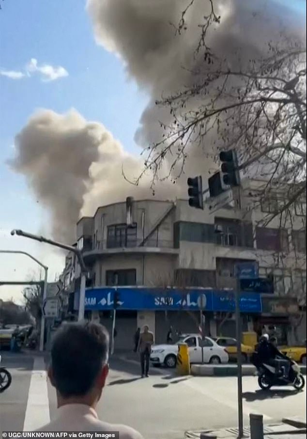 TOPSHOT - This video grab taken from UGC images posted on social media on February 28, 2026, and verified by AFPTV teams in Paris, shows a man looking on as a plume of smoke rises following a repoted explosion in Tehran. Two loud blasts were heard in Tehran on February 28 morning by AFP journalists, and two plumes of thick smoke were seen over the centre and east of the Iranian capital. Israel's defence ministry announced it had launched a "preemptive strike" on Iran as sirens sounded in Jerusalem and people across the country received phone alerts about an "extremely serious" threat. (Photo by various sources / AFP via Getty Images) / - Israel OUT / RESTRICTED TO EDITORIAL USE - MANDATORY CREDIT AFP -  SOURCE: UGC / UNKNOWN - DISTRIBUTED AS A SERVICE TO CLIENTS - NO RESALE - NO ACCESS ISRAEL MEDIA/PERSIAN LANGUAGE TV STATIONS OUTSIDE IRAN/ STRICTLY NO ACCESS BBC PERSIAN/ VOA PERSIAN/ MANOTO-1 TV/ IRAN INTERNATIONAL/RADIO FARDA - AFP IS NOT RESPONSIBLE FOR ANY DIGITAL ALTERATIONS TO T