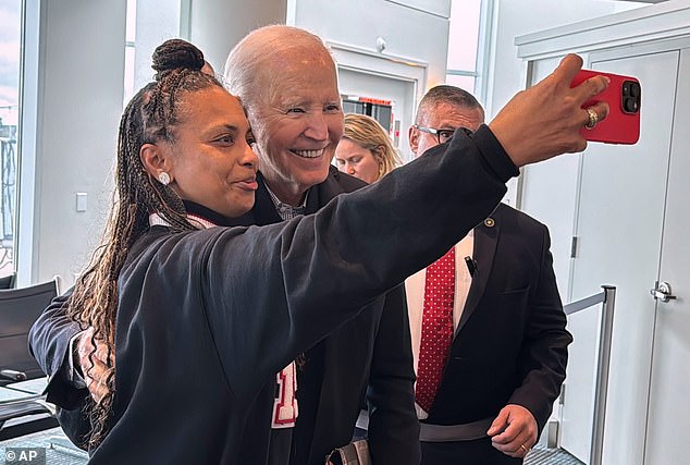 Former President Joe Biden takes another selfie with a passenger at Ronald Reagan Washington National Airport before traveling to Columbia, South Carolina to celebrate the anniversary of his 2020 primary win in the Palmetto state